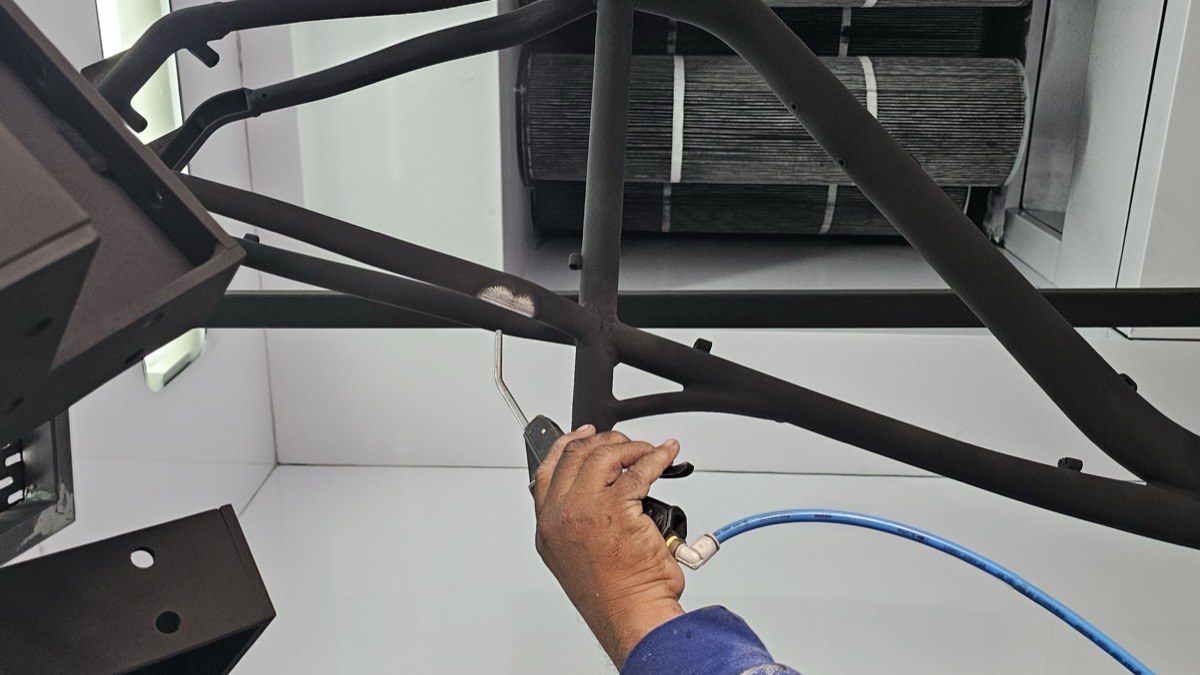 Aplicación de pintura electrostática sobre marco de acero en cabina de pintura de TESEY